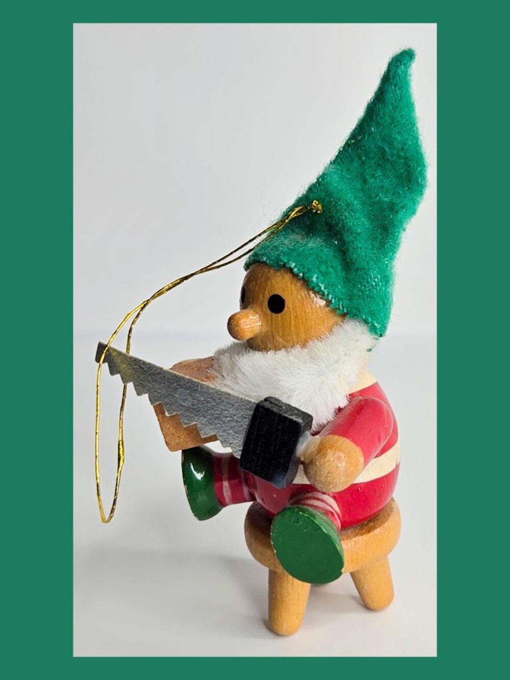 Vintage wooden German Christmas ornament elf sitting on a stool with saw